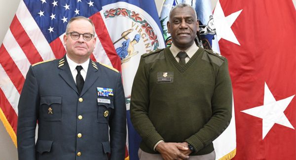 VMI superintendent, Maj. Gen. Wins poses in front of official flags with the Swedish Defense Minister.