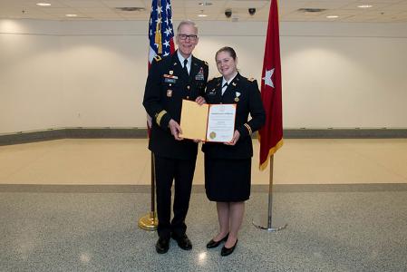 A professor stands with a man with certificate