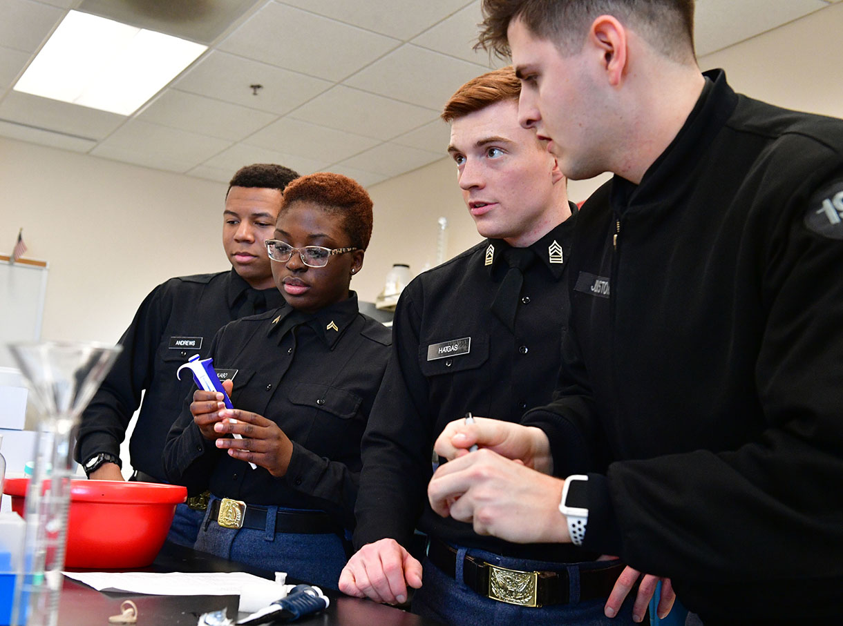 Four cadets stand in a biology lab