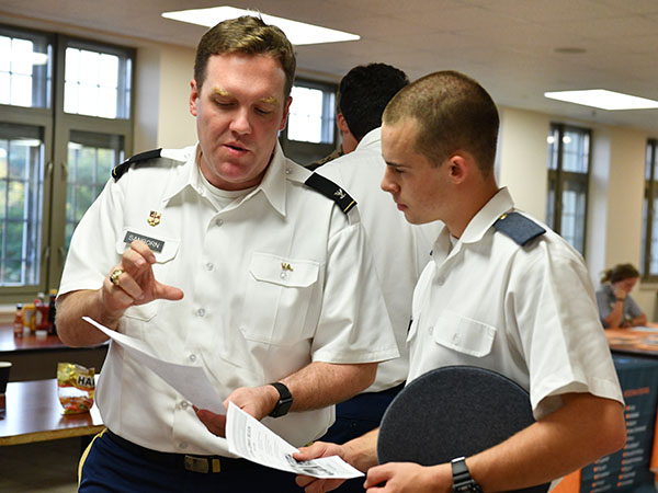 A professor is pictured talking to a cadet