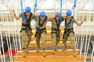 VMI Air Force ROTC cadets walking across suspended beams high over gymnasium