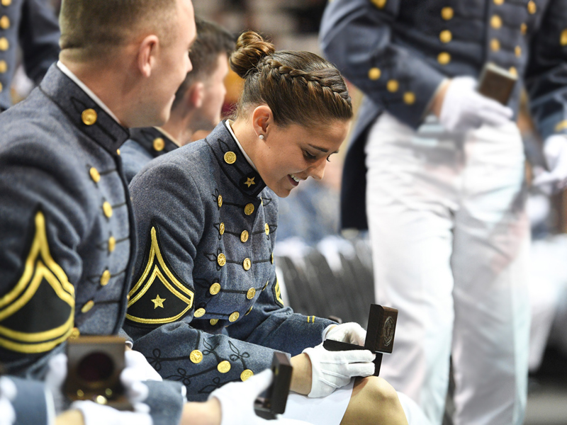 VMI cadet looking down and smiling at class ring that she holds on her lap