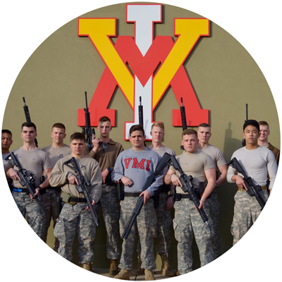 Three Gun Club cadet members group holding rifle, pistol, shotgun in front of wall with large VMI logo circle photo