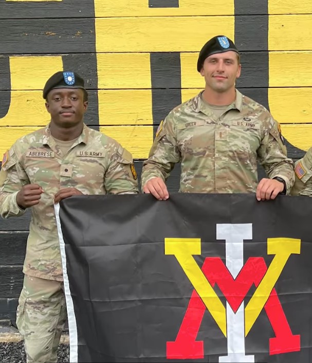 Ebenezer Abebrese poses with a VMI glaf at Army training.