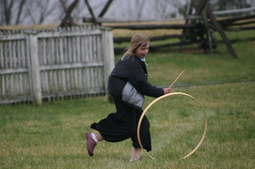 Photo of young girl rolling a hoop