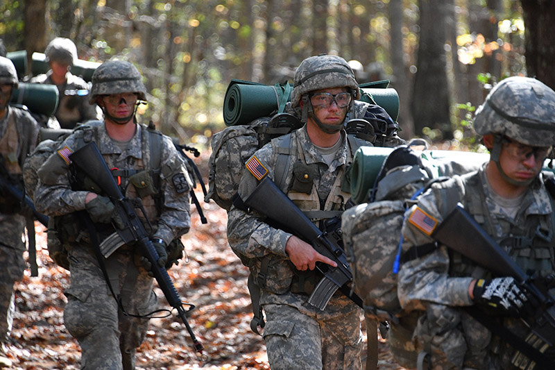 Cadets patrol through the forest during field training exercises.