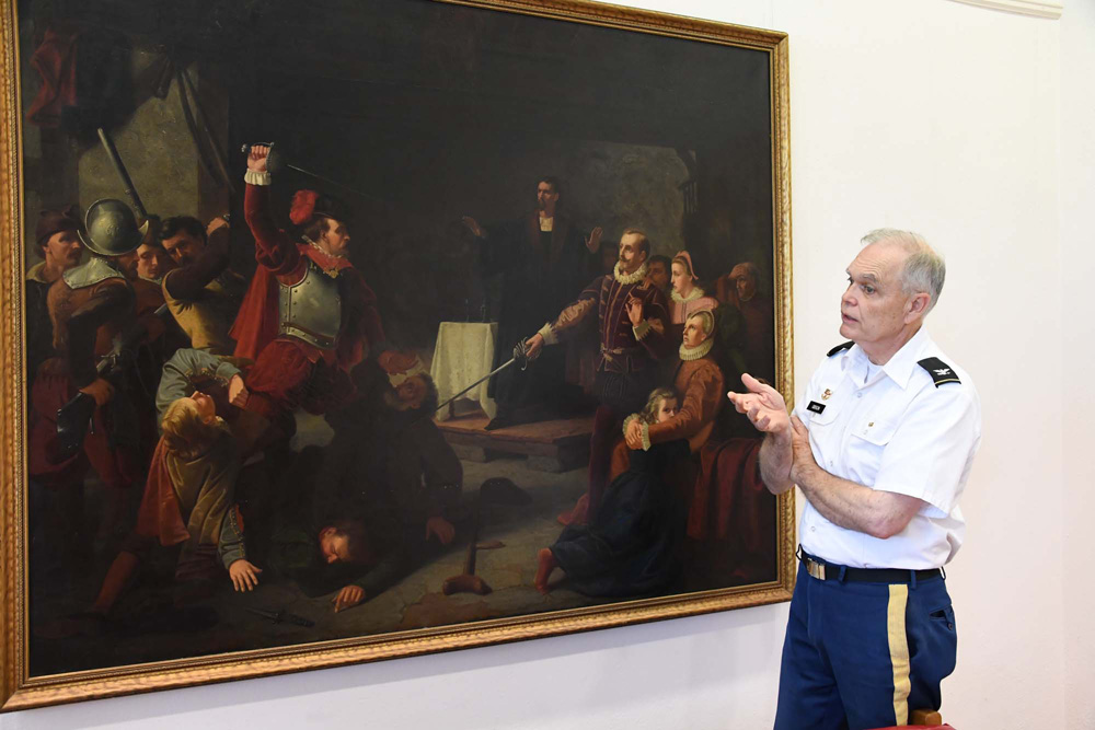 Col. Keith Gibson stands next to the painting 