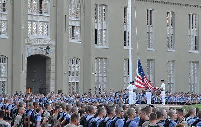 Cadets form up on the bricks while the U.S. flag is raised.