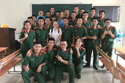 Cadet Hannah Gillan Poses with a group of students in Vietnam.