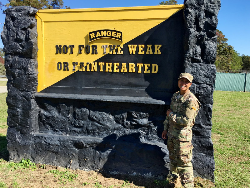 Nina Srikongyos ’15 poses in front the Army Ranger school sign at Victory Pond in Fort Benning, Georgia, after her graduation in November.—Photo courtesy of Nina Srikongyos ’15.