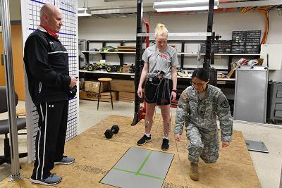Col. Mike Krackow and Maj. Joyce Blandino show Jamie Foster ’20 how to lunge forward onto the force plate to measure her muscular electrical impulses in Nichols Engineering Building March 6.