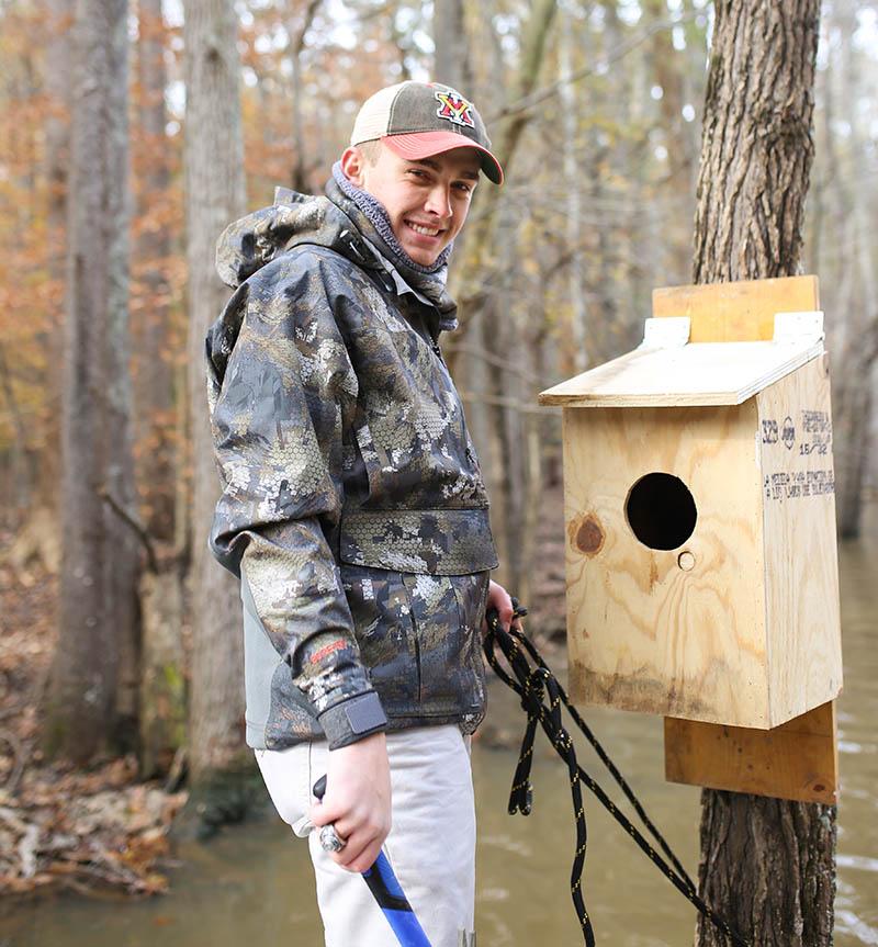 Mason Briggs '20 installs a duck box for habitat restoration. 