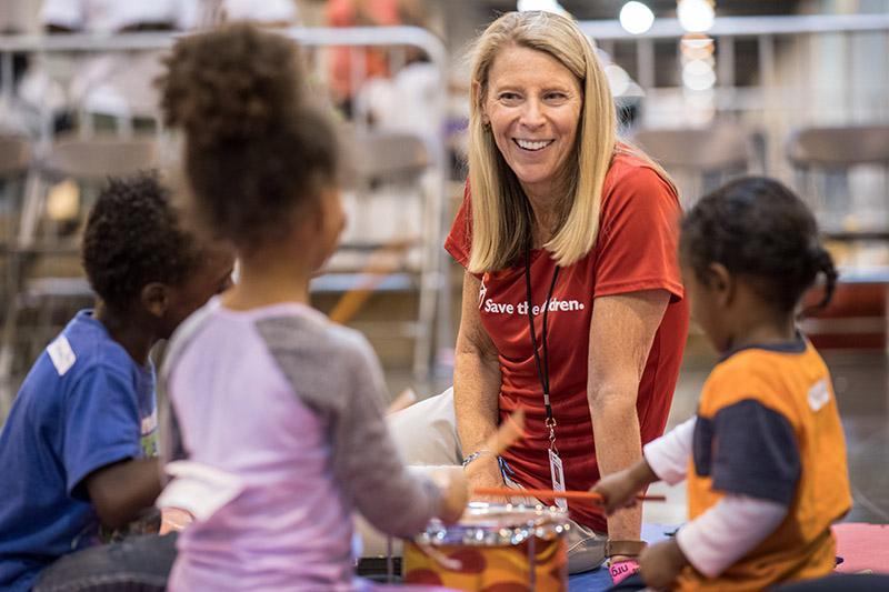 Carolyn Miles speaks with a group of children.